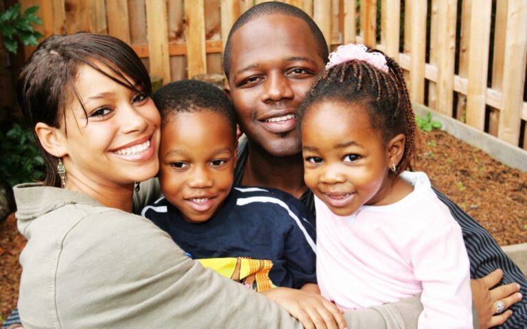 A man and woman holding children