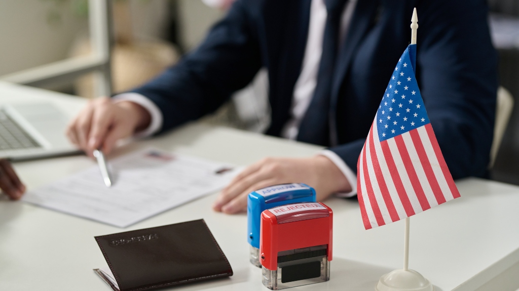 Close up of approved and rejected stamps on table in US immigration office with flag