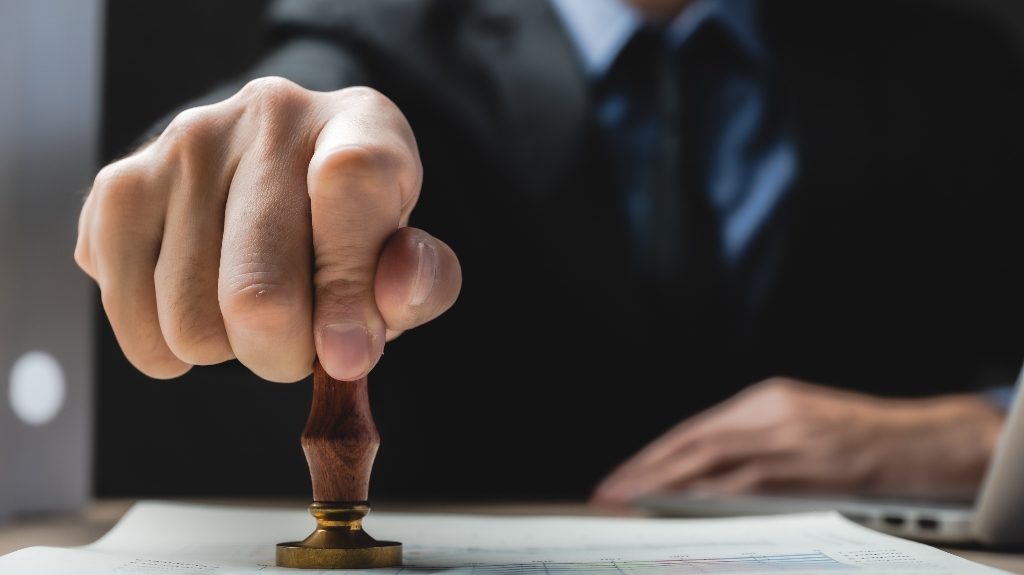Man is putting stamp on the document