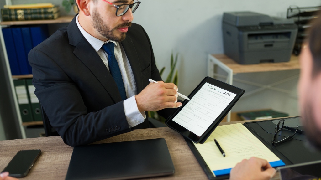 Closeup of immigration lawyer guiding a client through a digital visa application
