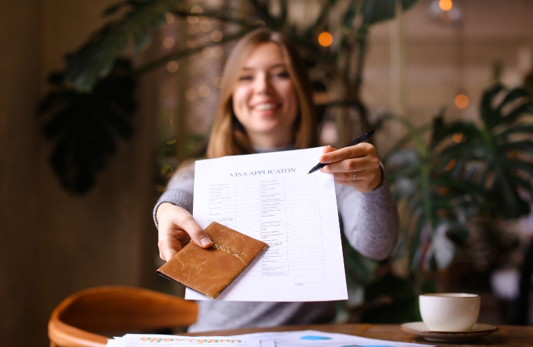 visa aplication and passport in young woman hands
